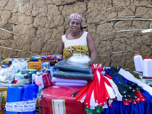 Learn about Ghana "Women participating in the Ghana Sewing Project proudly display their handmade garments, symbolizing their newfound financial independence achieved through microfinance initiatives."