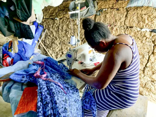 Ghana Sewing Project proudly display their handmade garments, symbolizing their newfound financial independence achieved through microfinance initiatives."