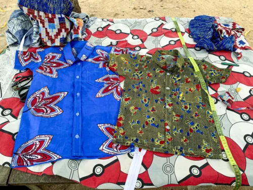Handmade products she made! "Women participating in the Ghana Sewing Project proudly display their handmade garments, symbolizing their newfound financial independence achieved through microfinance initiatives."